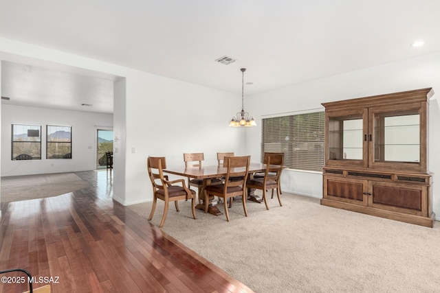 carpeted dining space featuring an inviting chandelier