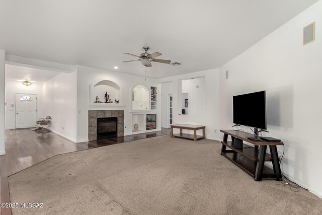 living room featuring a fireplace, carpet, and ceiling fan