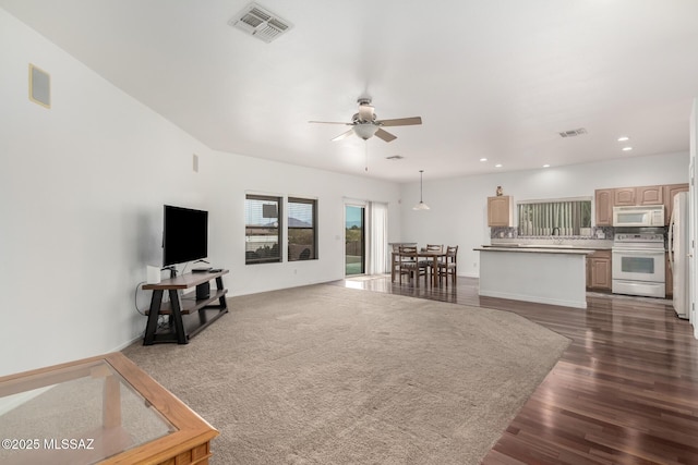 living room featuring ceiling fan and dark hardwood / wood-style floors