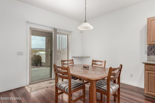 dining space with dark hardwood / wood-style flooring