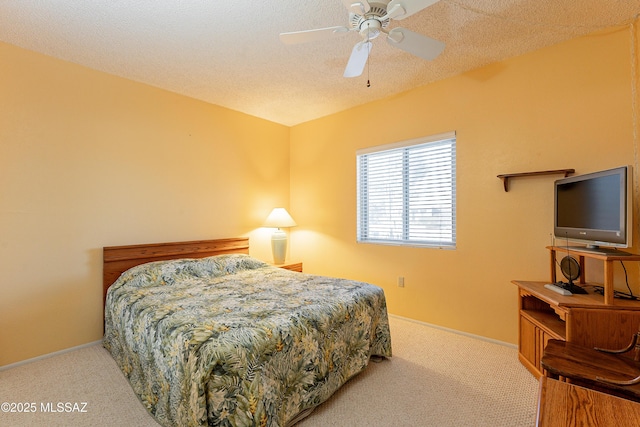 bedroom with a textured ceiling, carpet flooring, and ceiling fan