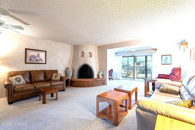 carpeted living room featuring a textured ceiling, a fireplace, and ceiling fan