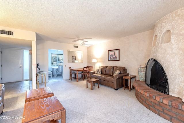 living room with a textured ceiling, a fireplace, and light carpet