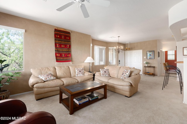 living room with light carpet and ceiling fan with notable chandelier