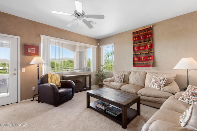 living room with a wealth of natural light, light colored carpet, and ceiling fan