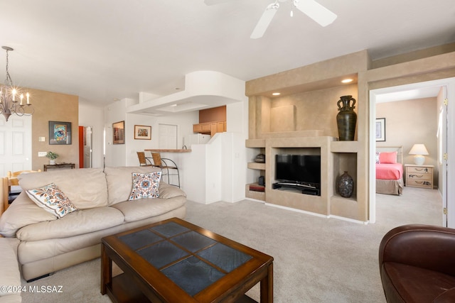 living room featuring light carpet and ceiling fan with notable chandelier