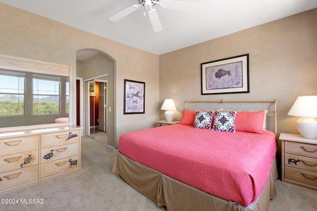 bedroom featuring a closet, light colored carpet, and ceiling fan