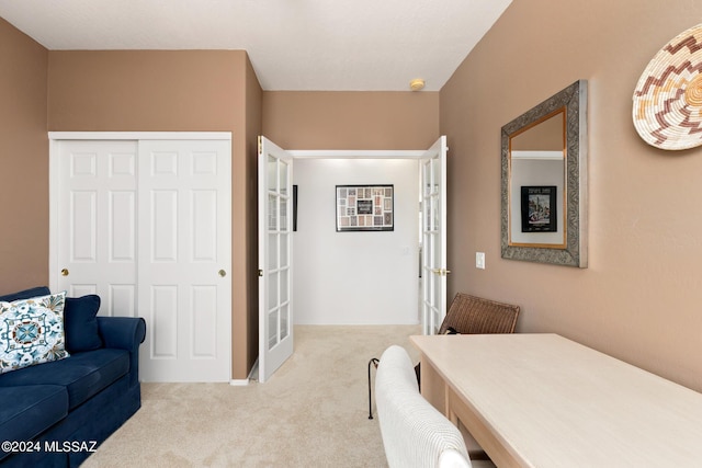 bedroom featuring french doors, light colored carpet, and a closet