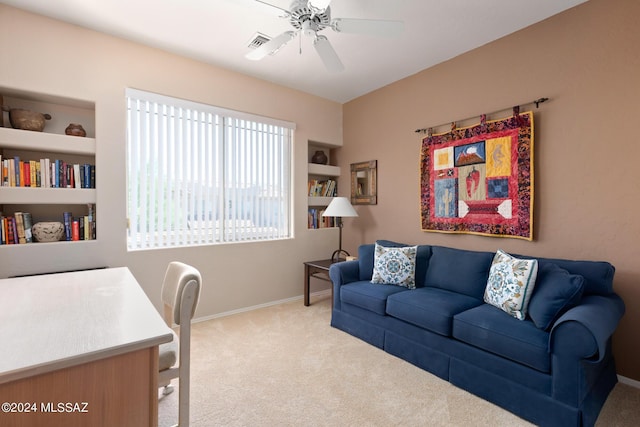 interior space featuring built in shelves, ceiling fan, and light carpet