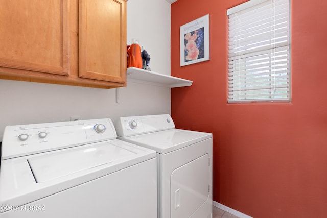 washroom featuring cabinets and washer and clothes dryer