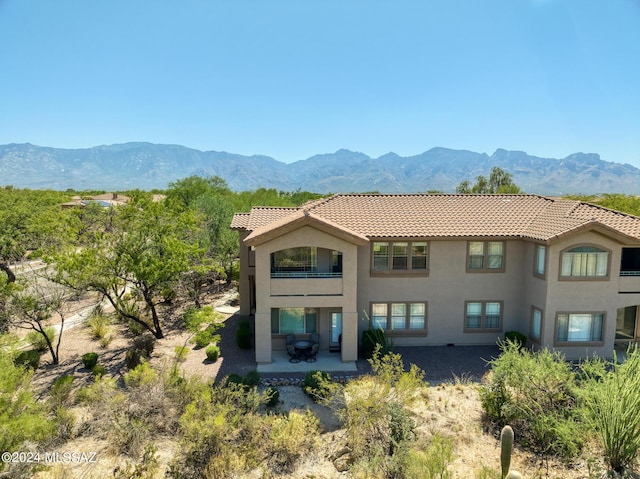 rear view of property featuring a mountain view and a patio