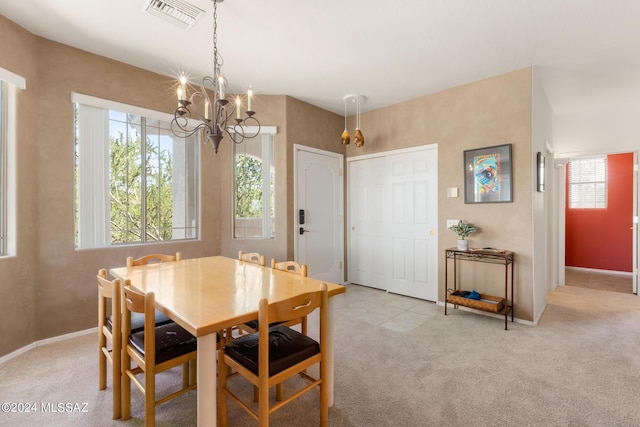 dining area with light carpet and a chandelier