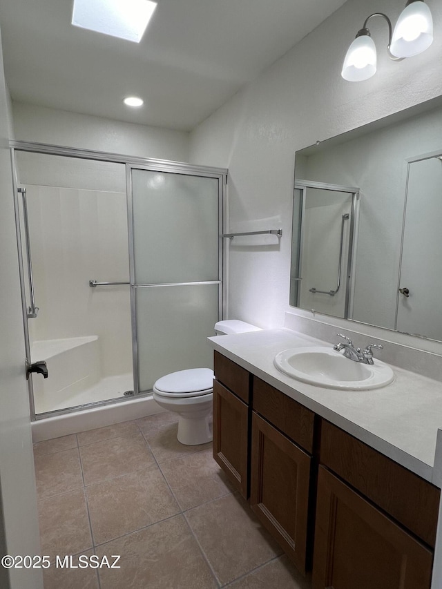 bathroom with tile patterned floors, vanity, toilet, and a shower with door