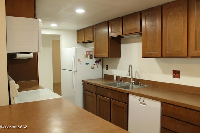 kitchen featuring white appliances and sink