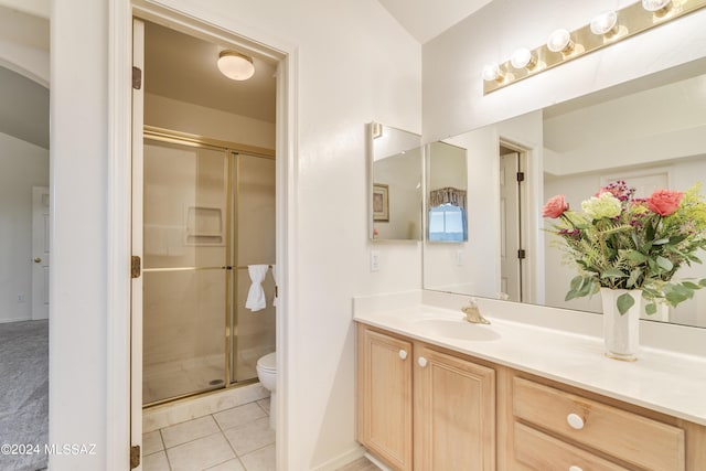 bathroom with tile patterned flooring, vanity, toilet, and walk in shower