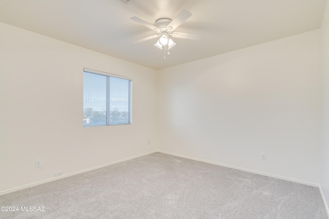 spare room featuring ceiling fan and light carpet