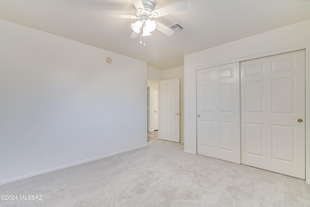 unfurnished bedroom with ceiling fan, a closet, and light carpet