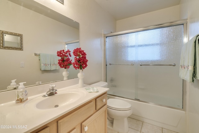 full bathroom with tile patterned floors, toilet, vanity, and combined bath / shower with glass door