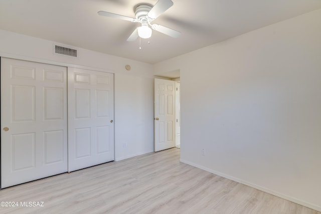 unfurnished bedroom with ceiling fan, light hardwood / wood-style floors, and a closet