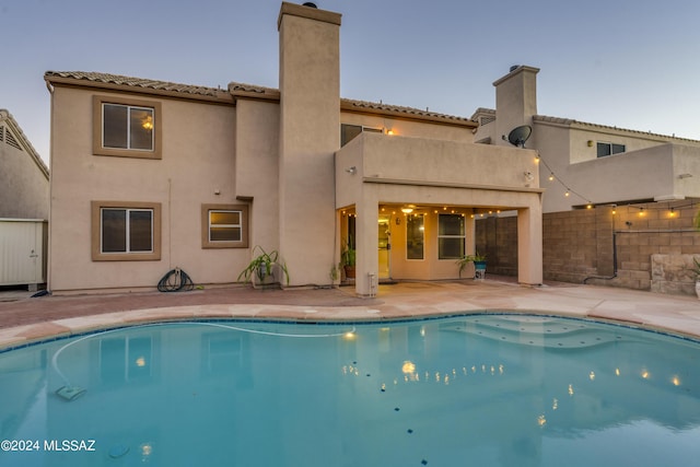 pool at dusk with a patio