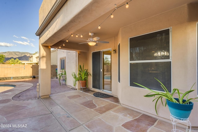 view of patio / terrace with ceiling fan and a mountain view