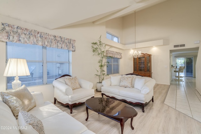 living room featuring wood-type flooring, a towering ceiling, and a notable chandelier