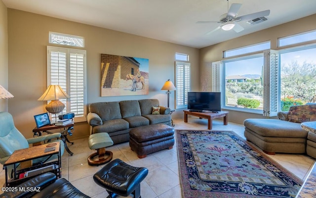 tiled living room with ceiling fan and a wealth of natural light