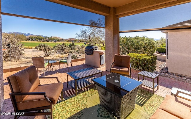 view of patio with outdoor lounge area, a mountain view, and an outdoor kitchen