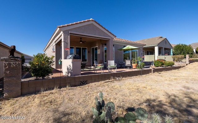 rear view of property featuring ceiling fan and a patio