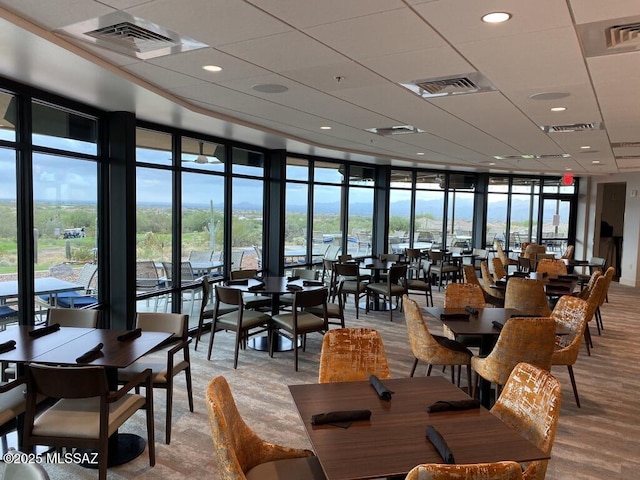 dining area featuring light hardwood / wood-style floors and a wall of windows