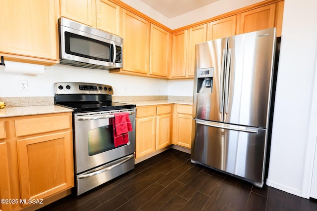 kitchen with appliances with stainless steel finishes, light brown cabinets, and light stone counters