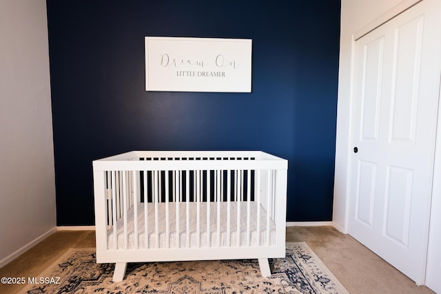 bedroom with a crib, baseboards, and carpet floors