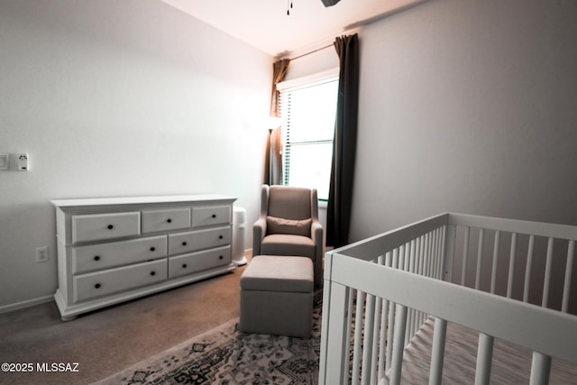 carpeted bedroom featuring baseboards and a nursery area