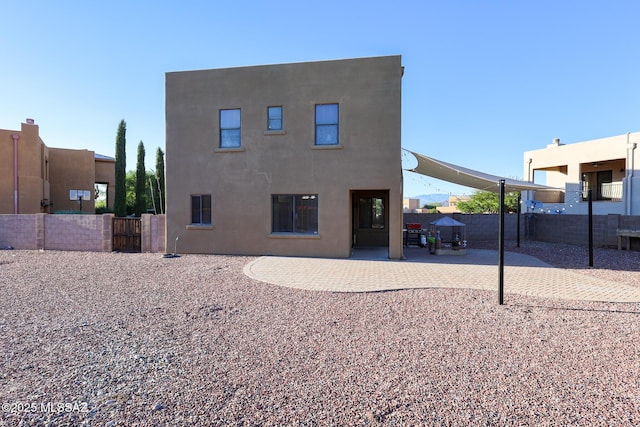 back of property featuring stucco siding, a patio, and fence