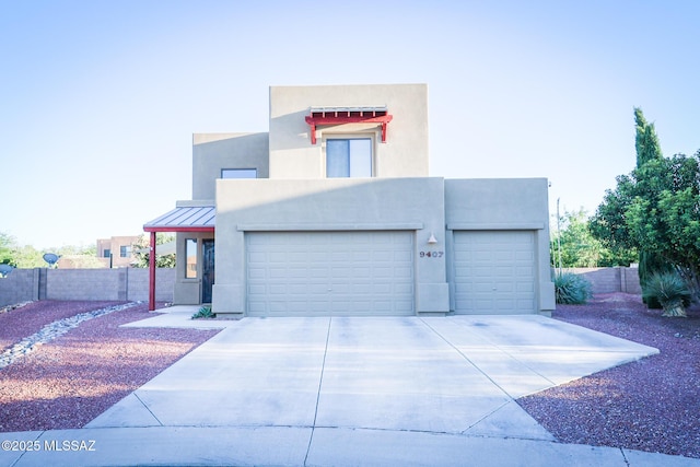 view of front of home with fence, a garage, driveway, and stucco siding