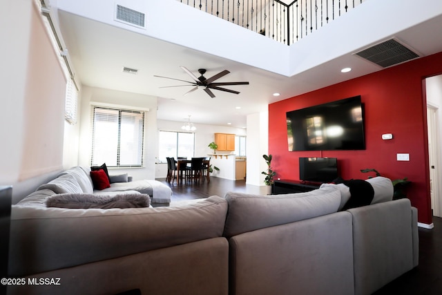 living room with recessed lighting, ceiling fan with notable chandelier, visible vents, and a towering ceiling