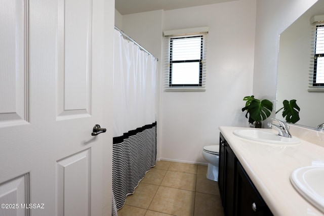 full bathroom with tile patterned floors, double vanity, toilet, and a sink