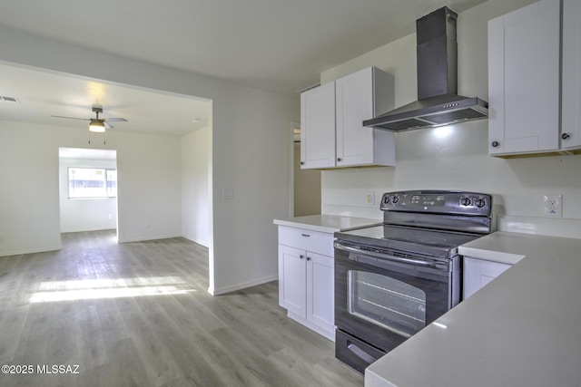 kitchen with white cabinets, electric range, light hardwood / wood-style flooring, and wall chimney exhaust hood