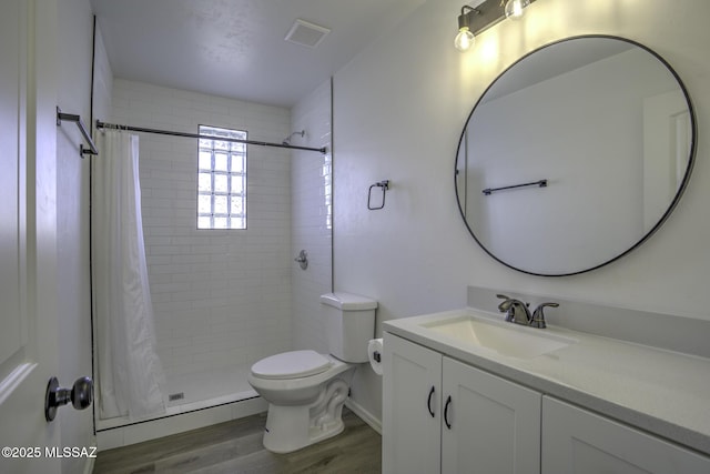 bathroom featuring hardwood / wood-style flooring, vanity, curtained shower, and toilet