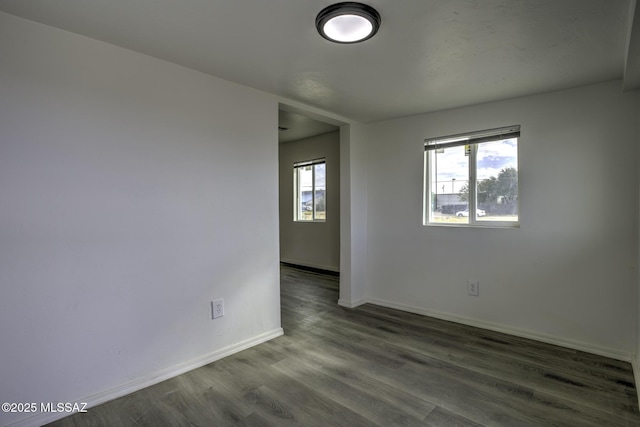 unfurnished room featuring dark hardwood / wood-style flooring and a healthy amount of sunlight