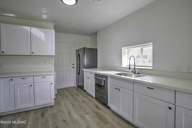 kitchen featuring sink, light hardwood / wood-style flooring, black dishwasher, fridge, and white cabinetry