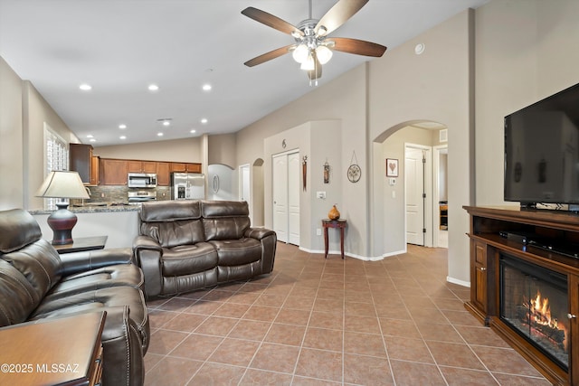 tiled living room with ceiling fan and lofted ceiling