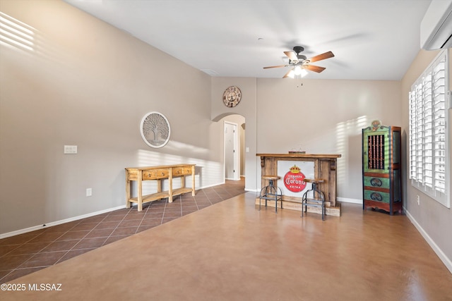 interior space featuring plenty of natural light, a wall unit AC, ceiling fan, and dark tile patterned floors