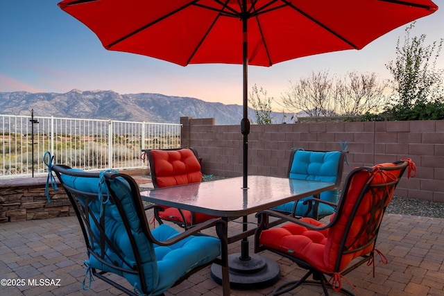 patio terrace at dusk featuring a mountain view