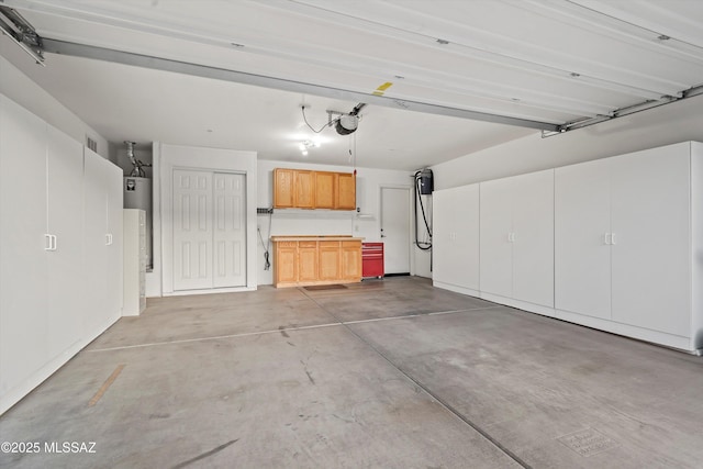 garage with a garage door opener and water heater