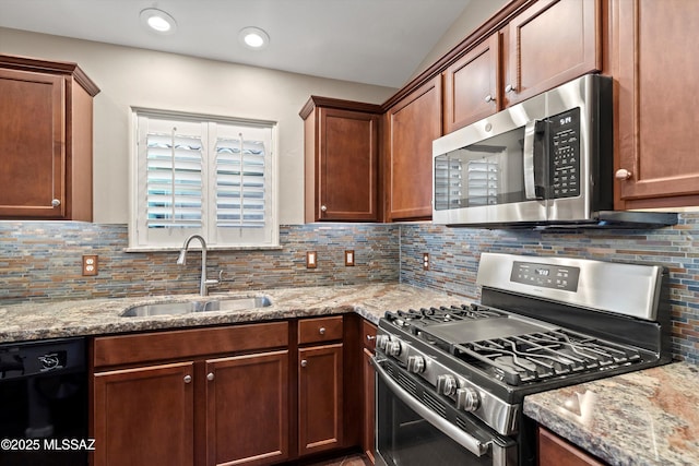 kitchen with sink, tasteful backsplash, light stone countertops, and appliances with stainless steel finishes