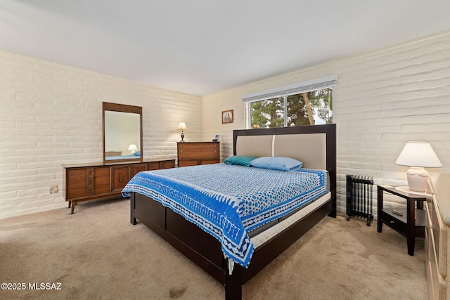 bedroom featuring light colored carpet and brick wall