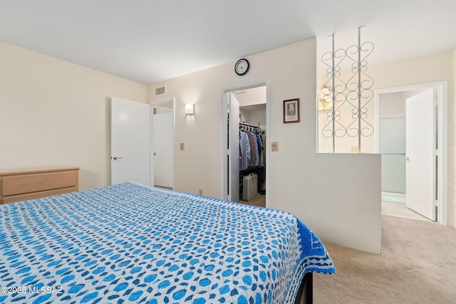 bedroom featuring a spacious closet, light carpet, radiator, and a closet