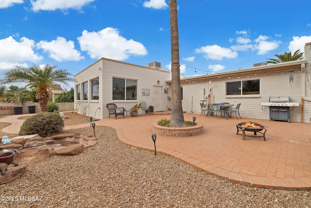 back of property with a patio area and an outdoor fire pit