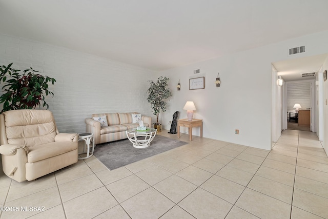 living room with brick wall and light tile patterned flooring